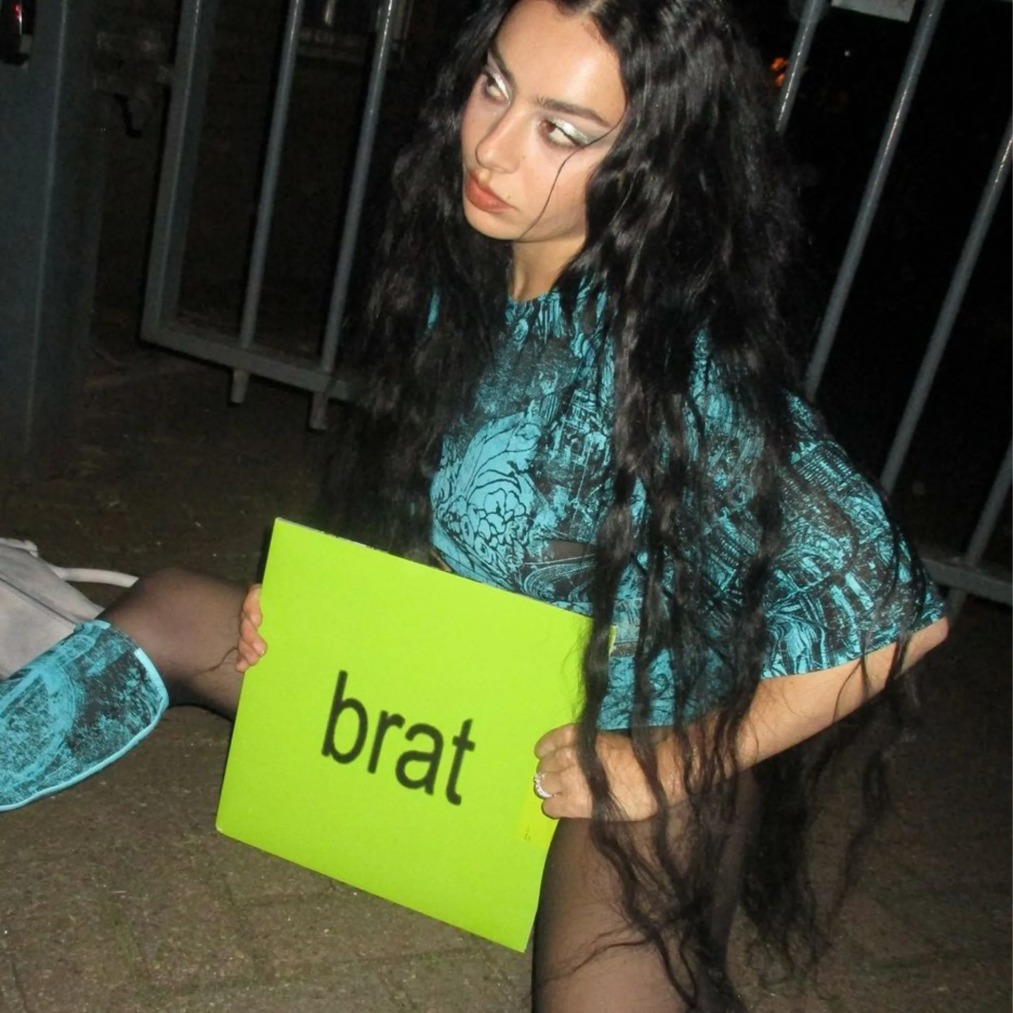 Charli XCX holding the brat album